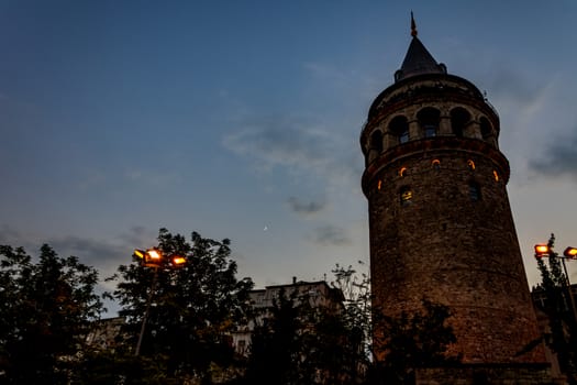 view to the Galata tower from the street while lights are switching on