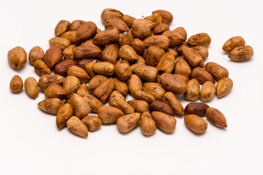 Pile of pealed hazelnuts on the white background