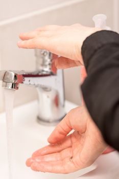 woman washing her hands in the bathroom