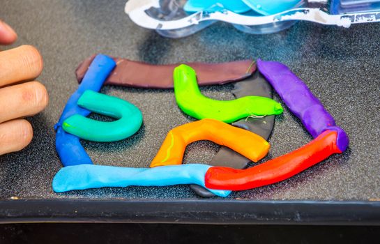 children playing with modeling clay of different colors in the school