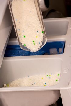 women is pouring powder detergent in wesh machine to washing dirty clothes