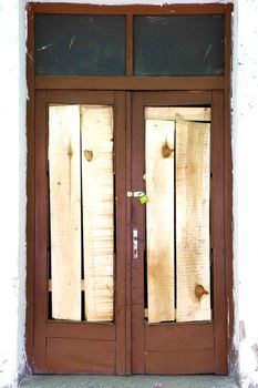 Old wooden brown rustic locked door with white wall