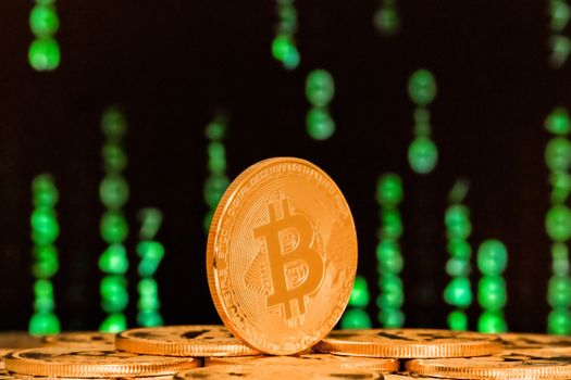 close up of bitcoin with sequence of green numbers in background