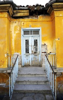 Old rustic yellow house with white door