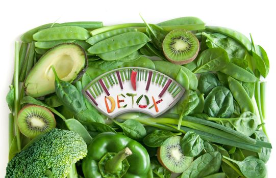 Green fruits and vegetables in the shape of bathroom weighing scales over a white background