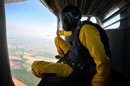 Parachutist in the airplane before jump on sunny day