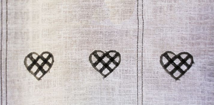 ornamental hearts sewn on a textile curtain