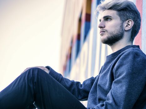 One handsome young man in urban setting in European city, standing