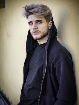 One handsome young man in urban setting in European city, standing