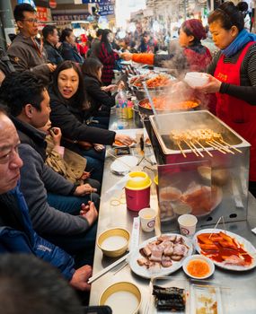seoul, south korea - 11th november 2017: foodies pack the crowded traditional food street stalls at gwangjang market
