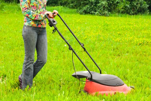 Mowing lawns, lawn mower on green grass