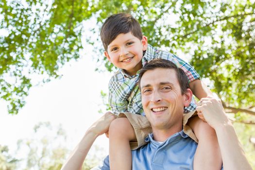 Mixed Race Father and Son Playing Piggyback Together in the Park.