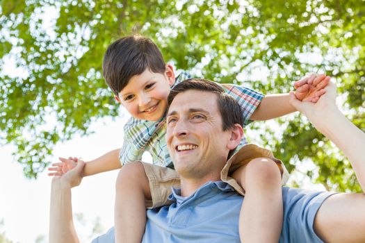 Mixed Race Father and Son Playing Piggyback Together in the Park.