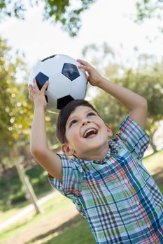 Cute Young Boy Playing with Soccer Ball Outdoors in the Park.