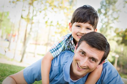 Mixed Race Father and Son Playing Together in the Park.