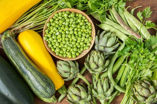 Fresh organic green vegetables wooden floor with copy space. Green and yellow vegetables background. Healthy eating background. Vegetarian food, organic food.