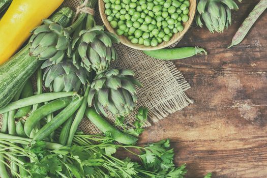 Fresh organic green vegetables wooden floor with copy space. Green and yellow vegetables background. Healthy eating background. Vegetarian food, organic food.