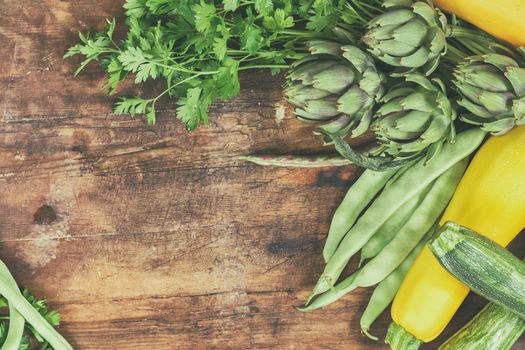 Fresh organic green vegetables wooden floor with copy space. Green and yellow vegetables background. Healthy eating background. Vegetarian food, organic food.