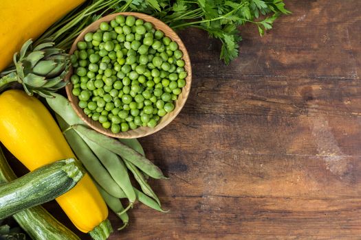 Fresh organic green vegetables wooden floor with copy space. Green and yellow vegetables background. Healthy eating background. Vegetarian food, organic food.