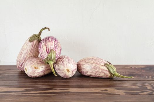 Purple graffiti eggplants on a wooden table in a vintage wooden background in rustic style, selective focus