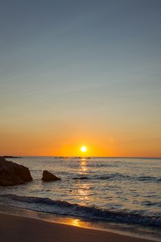 The sun rising up in Cala Ginepro in Sardinia next to Bidderosa, Italy