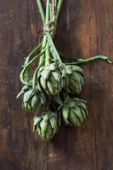 Supplies and materials for artichoke bouquet on wooden background
