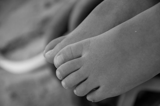 Baby feet over the sand black and white