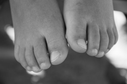 Baby feet over the sand black and white