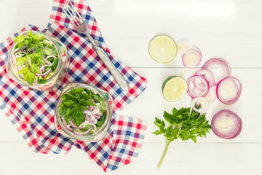 Homemade healthy salads with vegetables, onion, parsley and lettuce in jar. Toning. Selective focus.