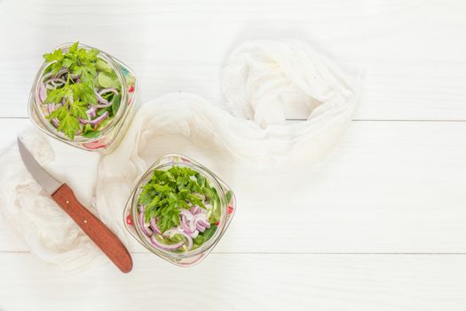 Homemade healthy salads with vegetables, onion, parsley and lettuce in jar. Toning. Selective focus.