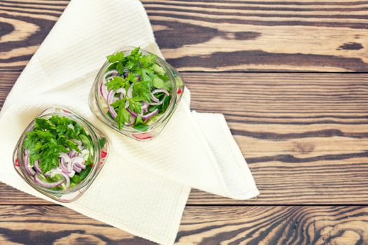 Homemade healthy salads with vegetables, onion, parsley and lettuce in jar. Toning. Selective focus.