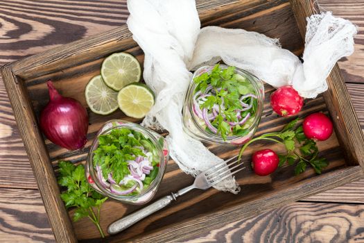 Homemade healthy salads with vegetables, onion, parsley and lettuce in jar. Toning. Selective focus.