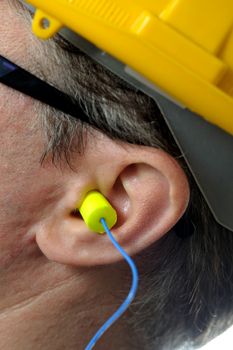 man with protective ear plugs and helmet
