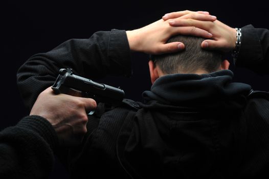 Robber Thief standing behind a men and holding gun