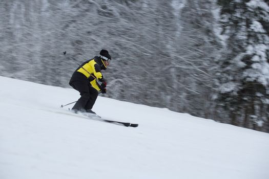 Skier on piste running downhill in beautiful hoarfrost winter landscape