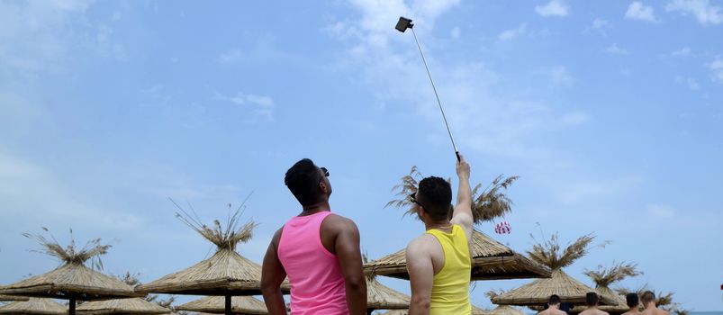 Two men making selfie photo on the beach