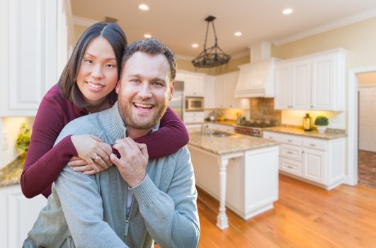 Mixed Race Caucasian and Chinese Couple Inside Beautiful Custom Kitchen.