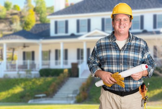 Contractor With Plans and Hard Hat In Front of Beautiful Custom House.