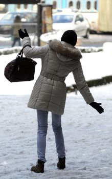 Young woman walking on slippery floor on snow