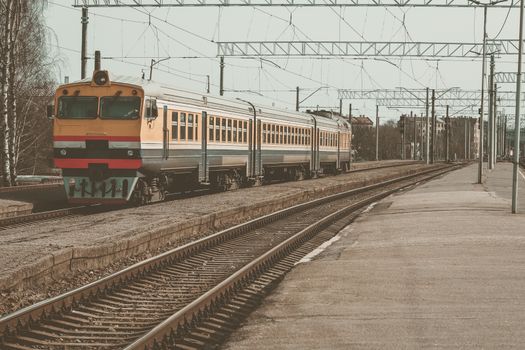 Old yellow passenger diesel train moving at the terminal