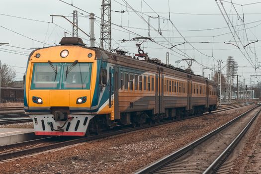 Yellow modern passenger electric train moving at the old terminal