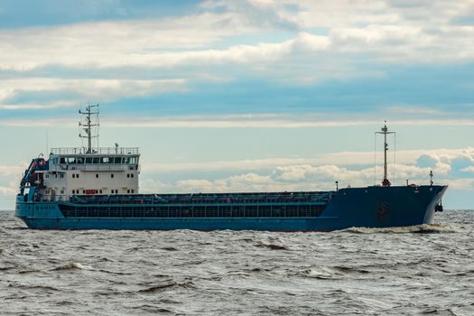 Merchandise import. Large blue cargo ship moving to Riga port