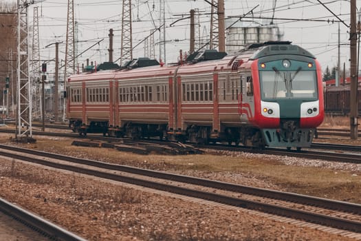 Red diesel passenger train driving at the old terminal