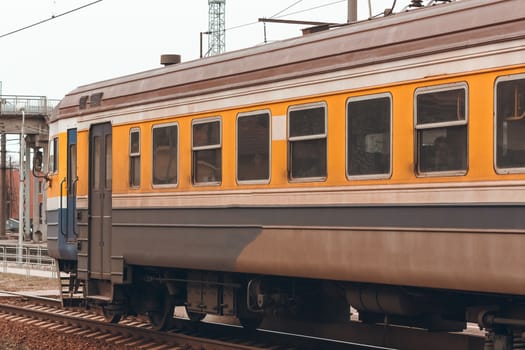 Old yellow passenger electric train driving at the terminal