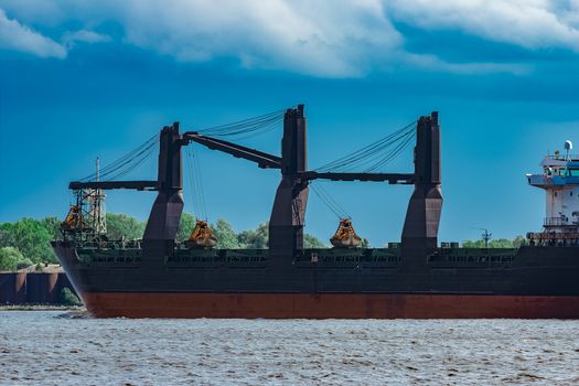 Merchandise import. Large blue cargo ship moving to Riga port