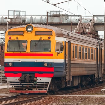 Old yellow passenger electric train driving at the terminal