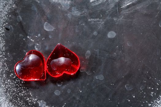 Valentines Day greeting card. Two red hearts in black frozen water with free space