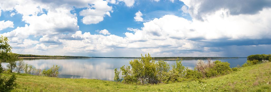 Bright, beautiful panorama of of the river on a sunny day with clouds.