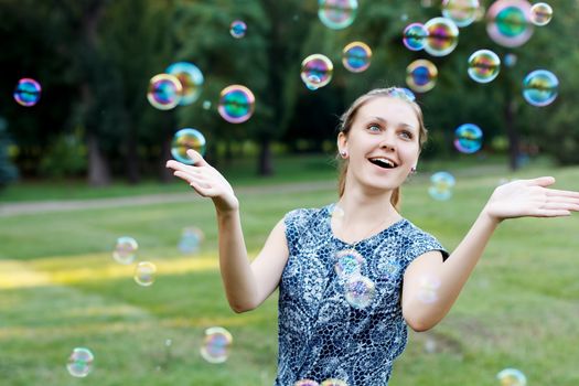 Beautiful girl in the park with soap bubbles.