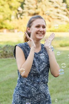 Beautiful girl in the park with soap bubbles.